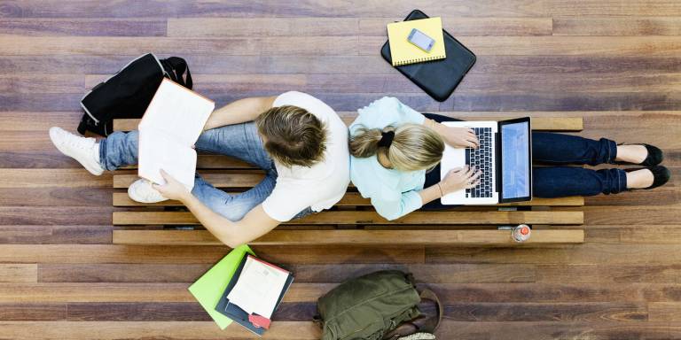 Kuvassa kaksi henkilöä seläkkäin opiskelee tietokoneella