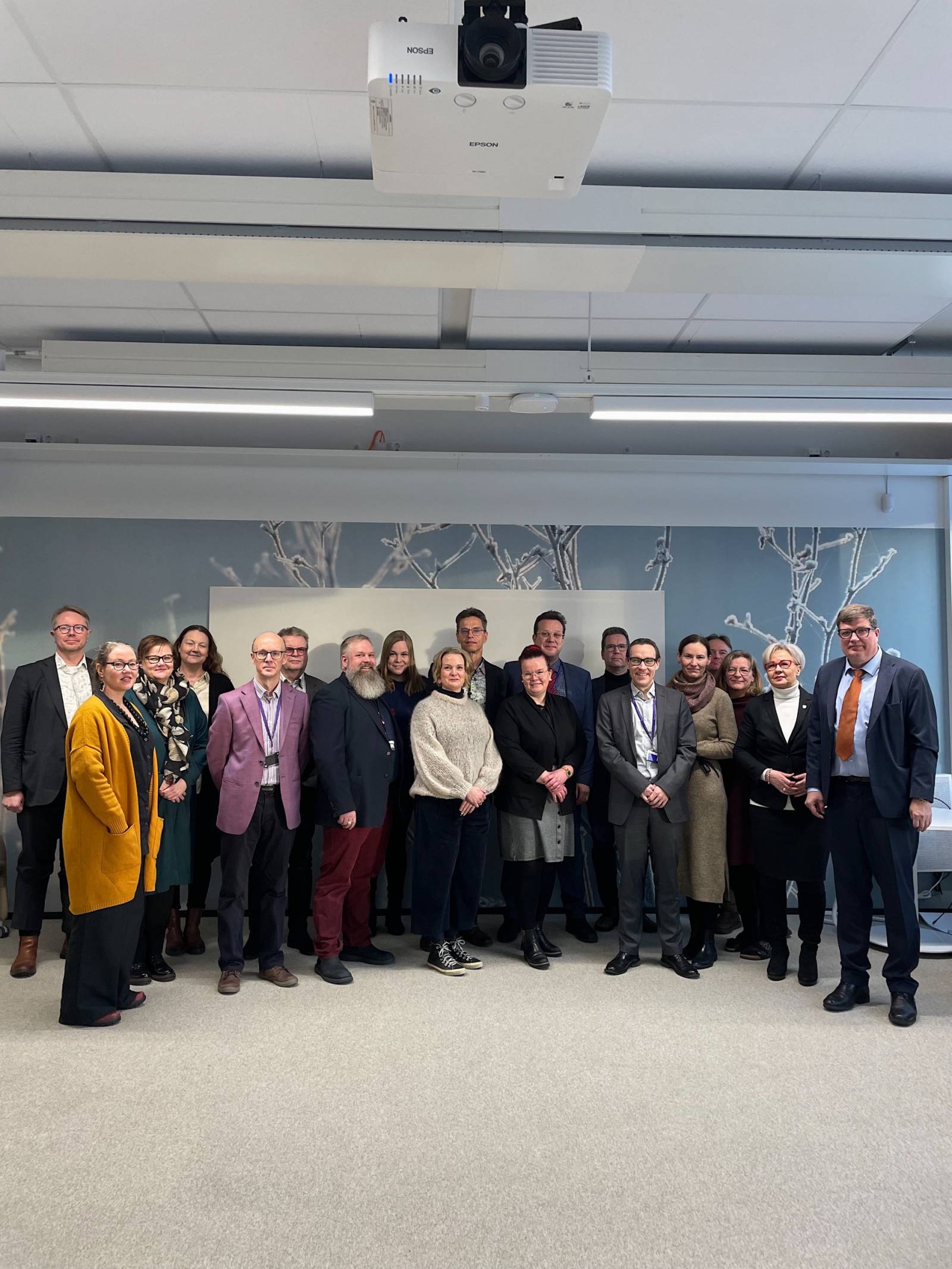 Ihmisiä seisomassa vierekkäin ryhmämuodostelmassa.