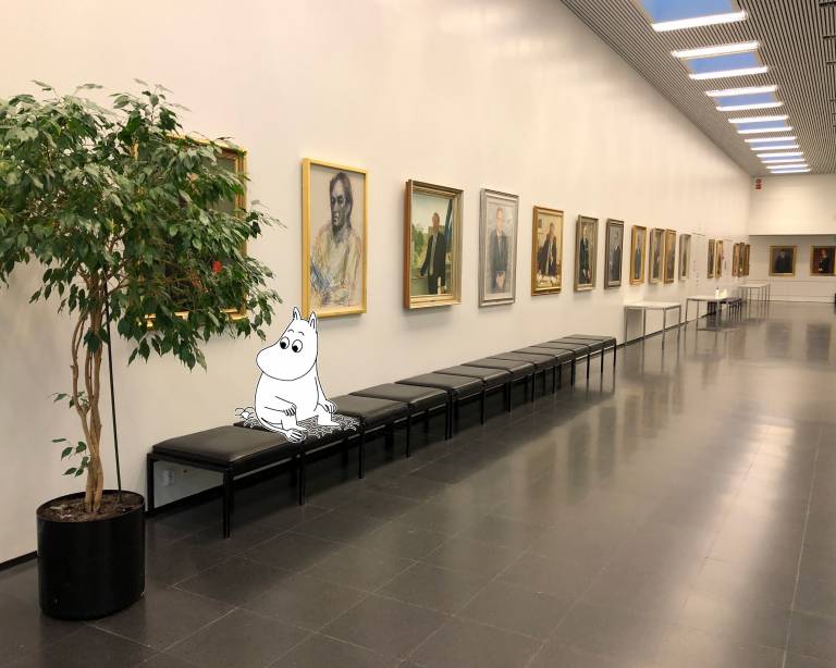 Moomintroll sitting in university lobby.