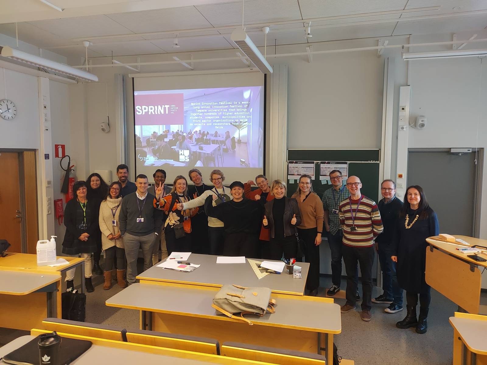 People standing in front of the screen in a classroom.