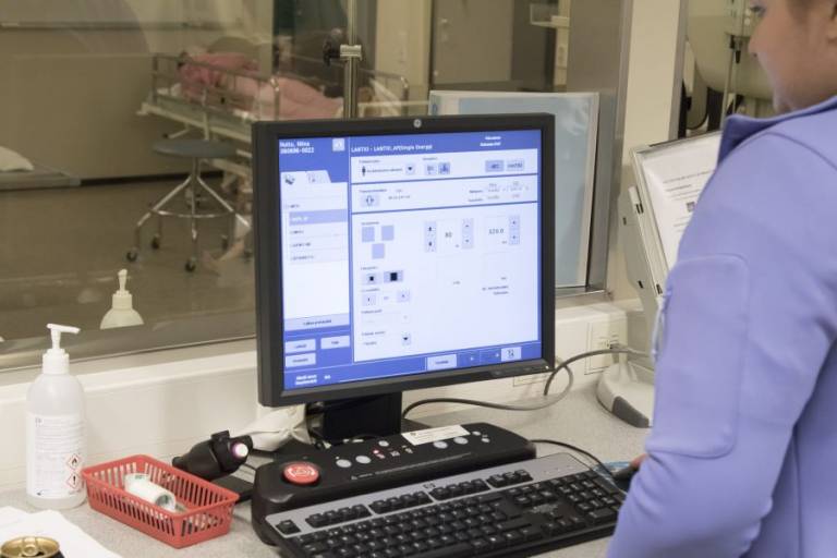 Mies tietokoneen näytön ääressä toimistoympäristössä.