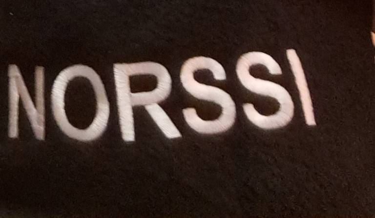 Kuva mustasta viltistä, jossa lukee valkoisella Norssi