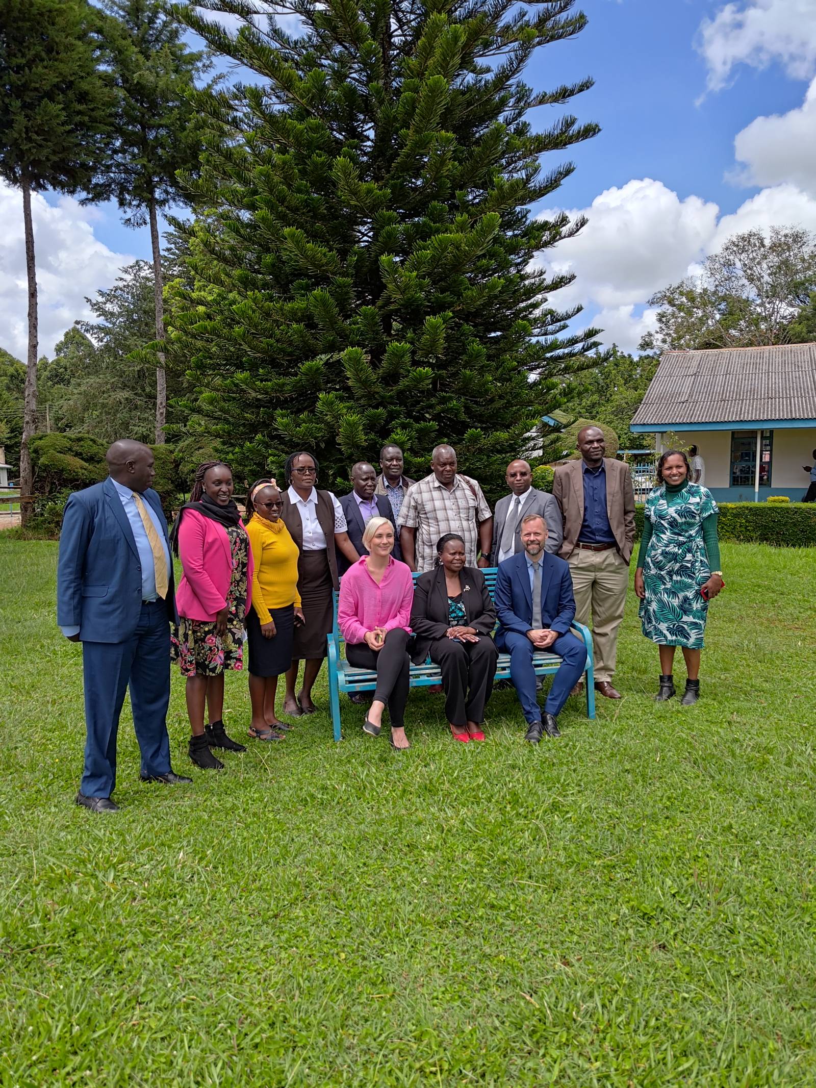 Ryhmä ihmisiä seisoo pihalla Keniassa.