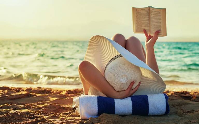 Ihminen makoilee meren rannalla.