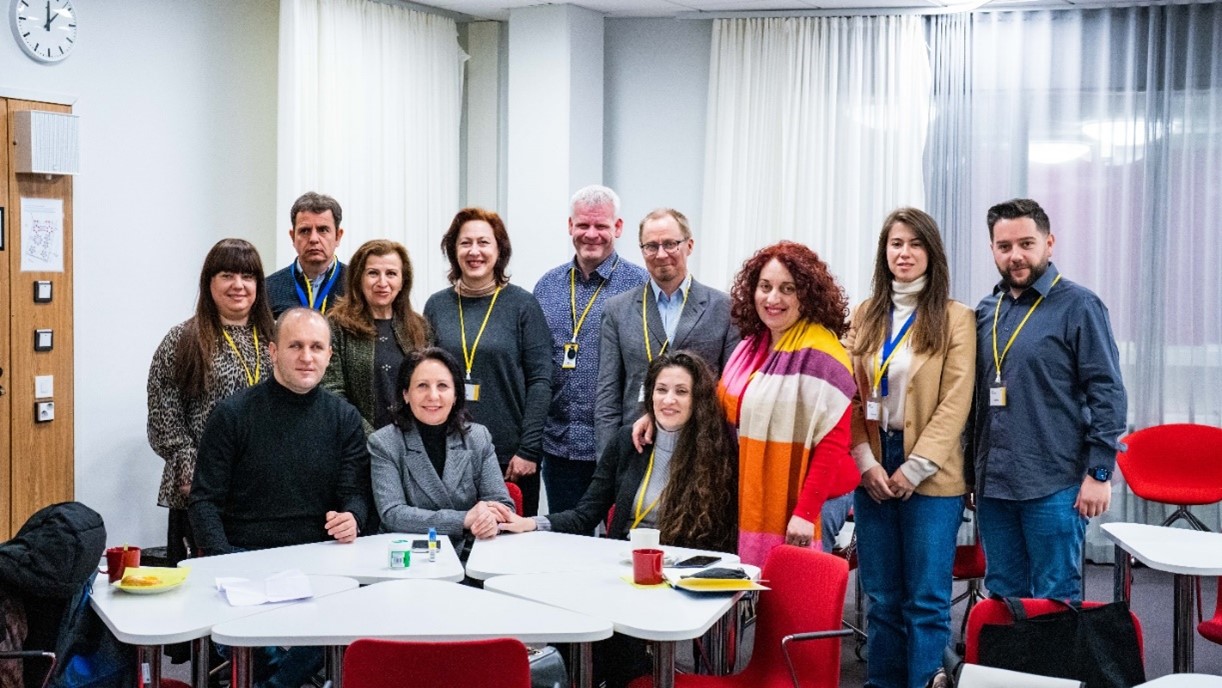 A group of people posing behind a white table.