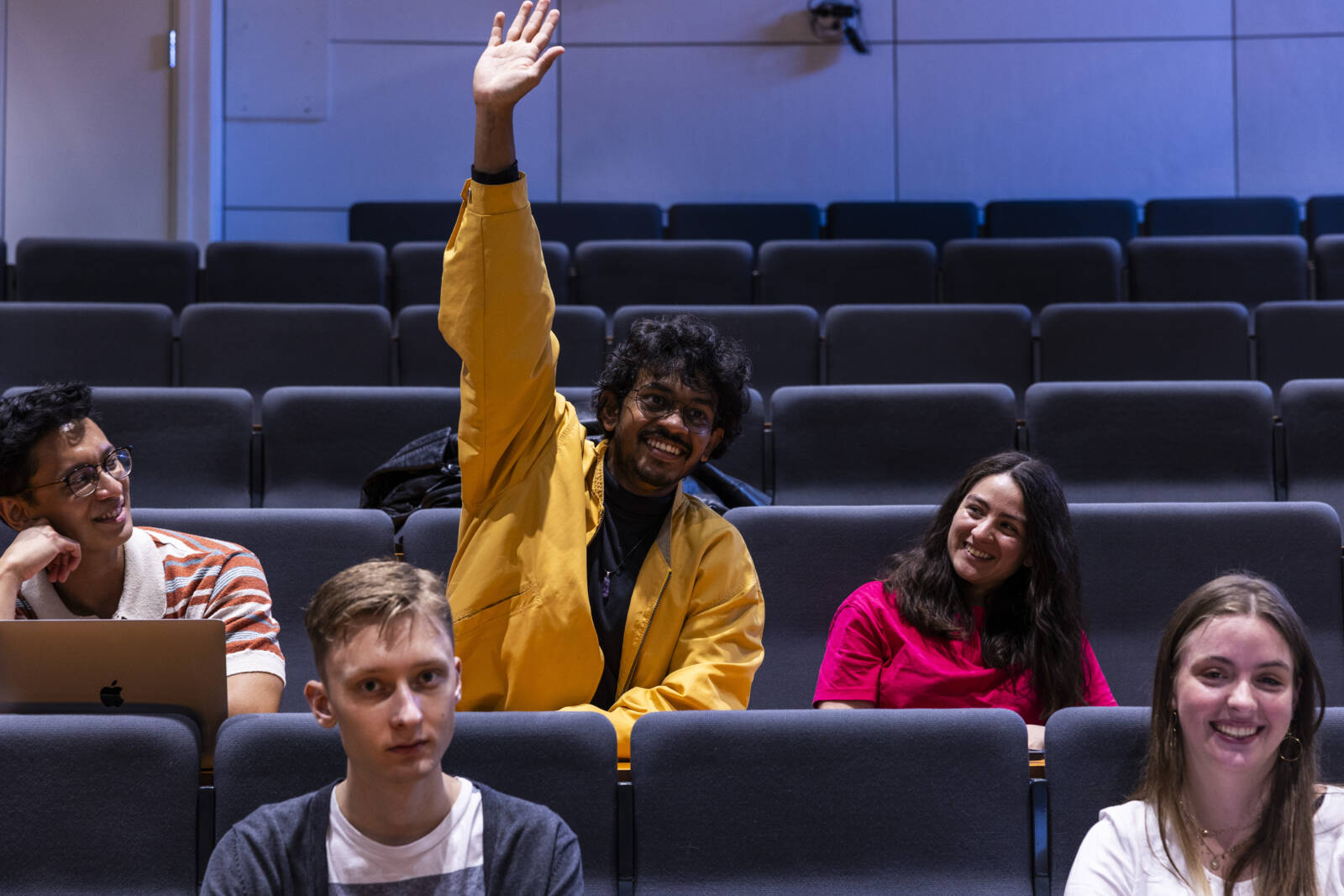 Viisi opiskelijaa luontosalissa. Yksi opiskelijoista viittaa innoissaan.