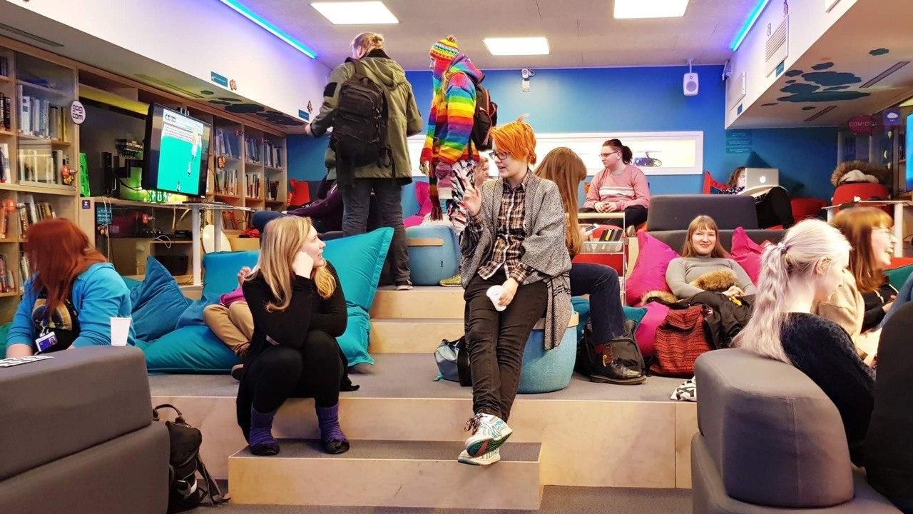 Ihmisiä istumassa Oasiksessa penkeillä ja sohvilla.