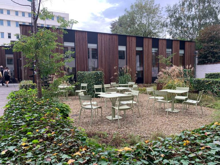 Tyhjiä pöytiä ja tuoleja pihalla rakennuksen edessä Brysselissä.