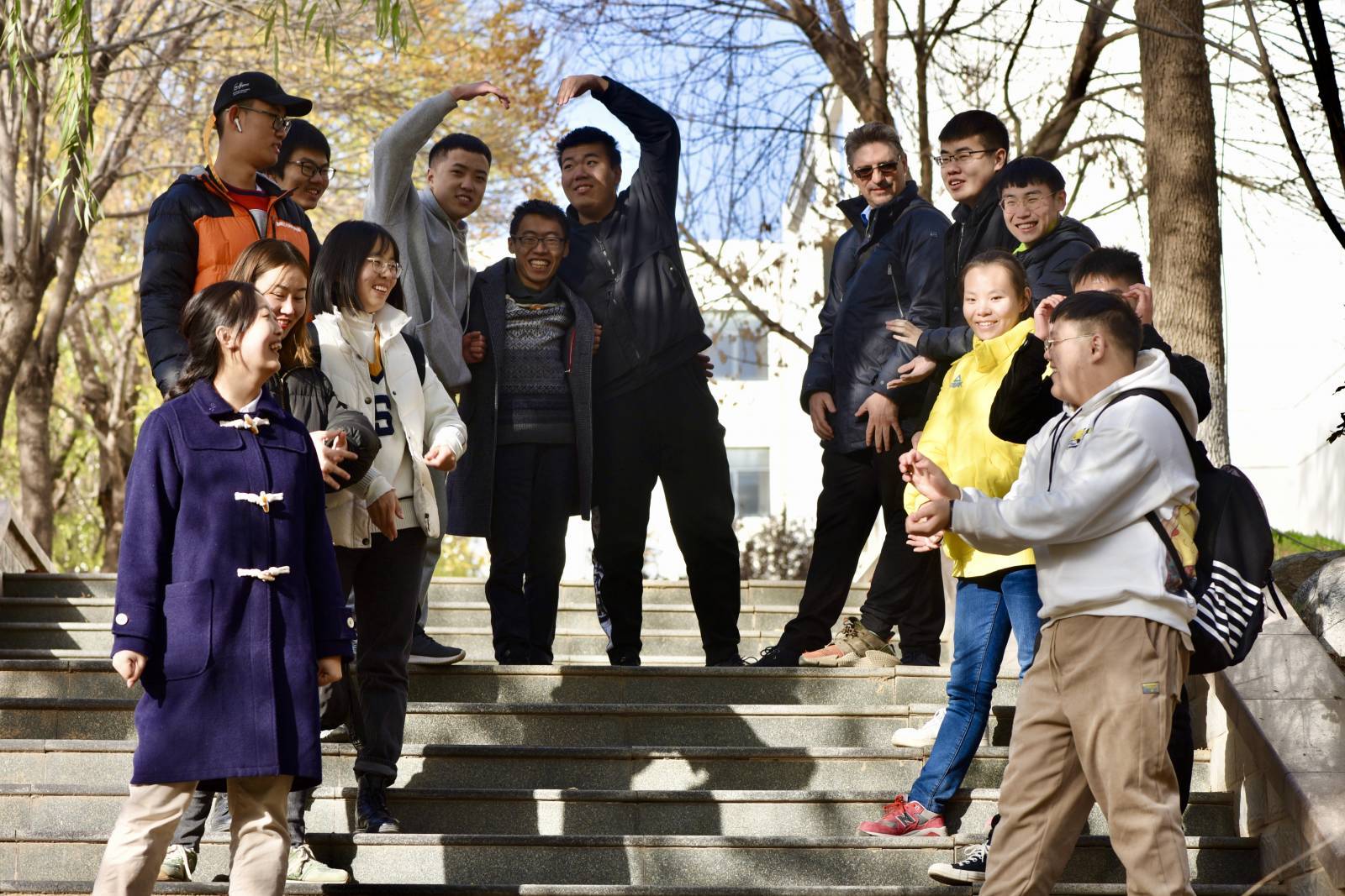Happy students standing outside on stairs.