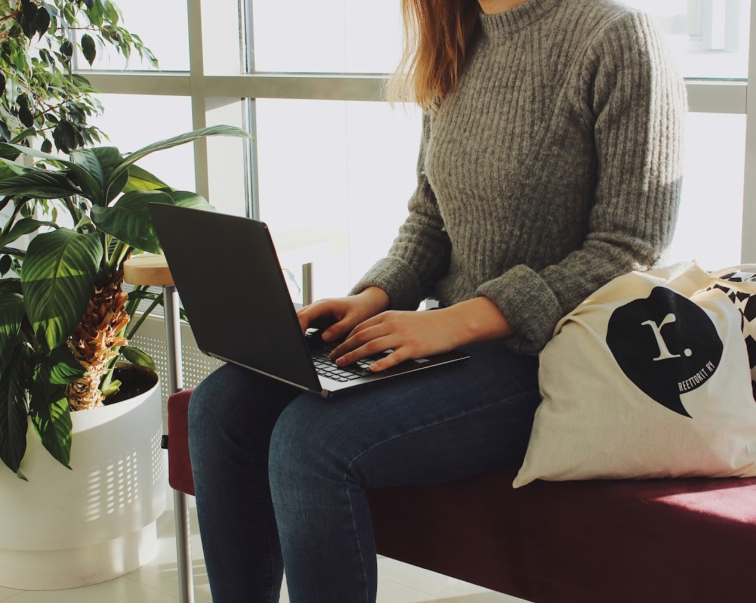 Opiskelija istuu tietokone sylissään