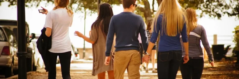 Viisi ystävystä takaapäin kuvattuna.