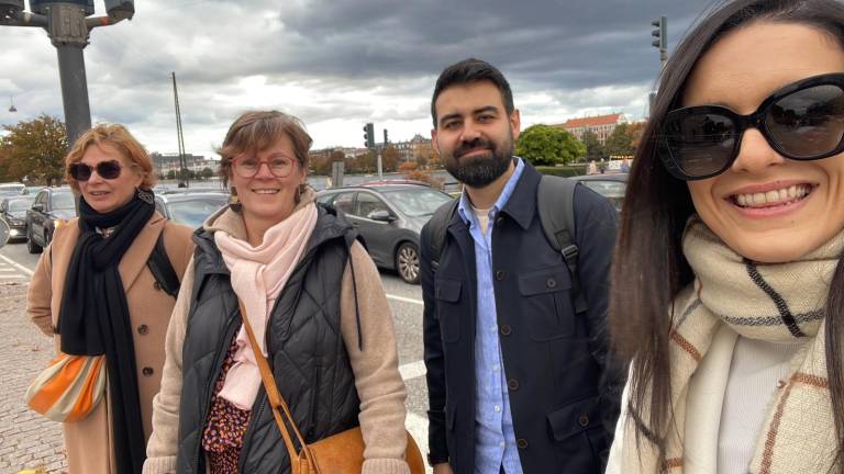 Neljä henkilöä hymyilee vierekkäin.