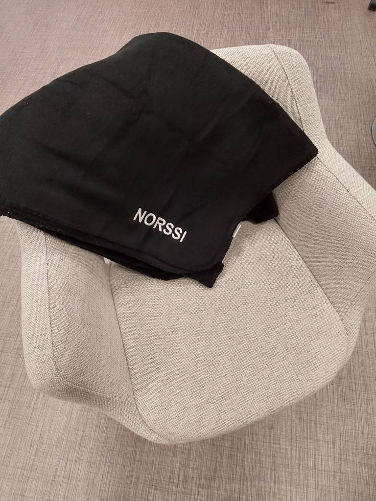 Kuva, jossa harmaa tuoli, jossa musta Norssi-viltti