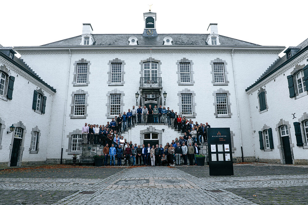 Iso valkoinen talo, jonka edessä seisoo paljon ihmisiä.