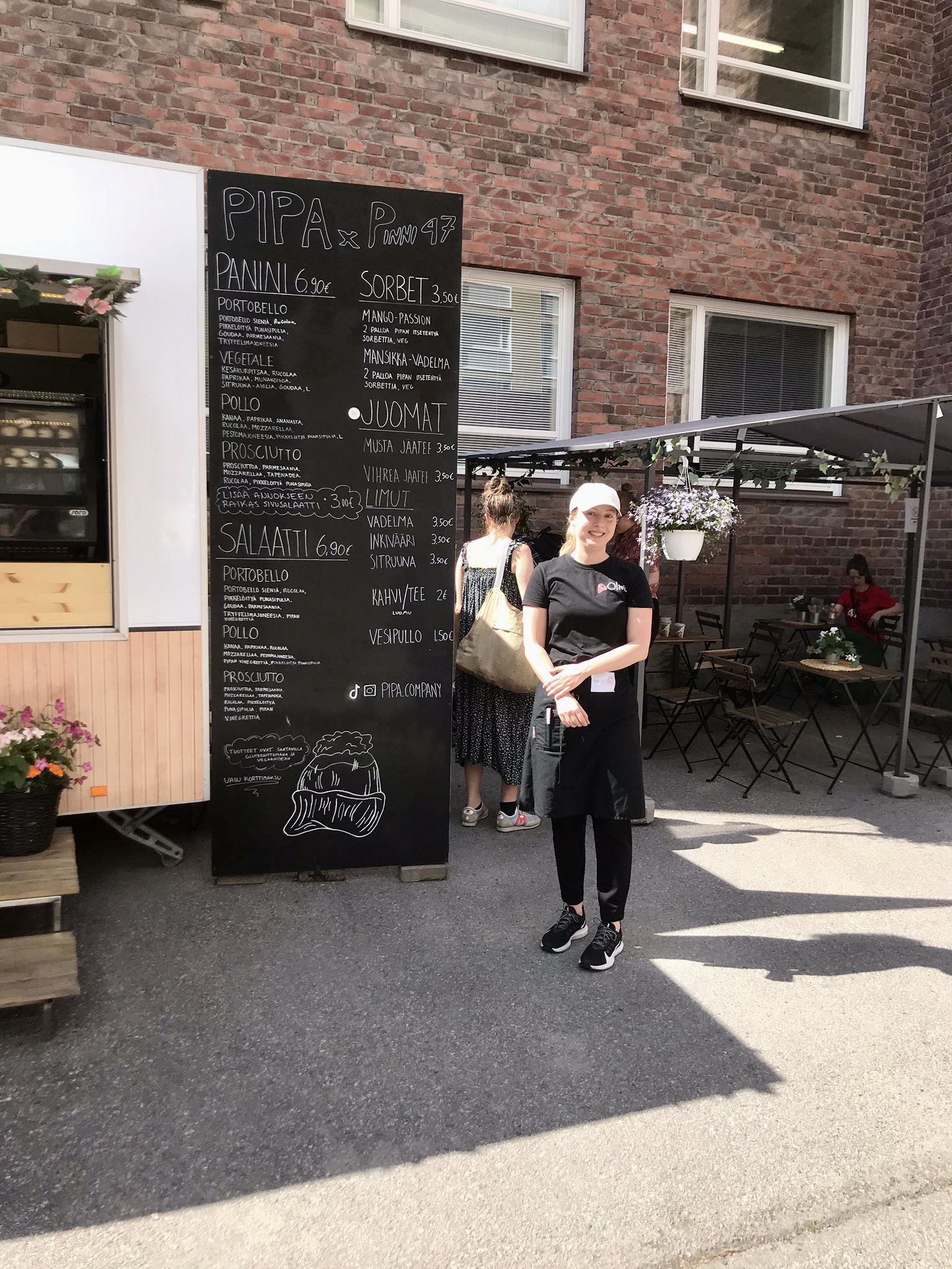 Nainen seisomassa kahvilavaunun vieressä ulkona.