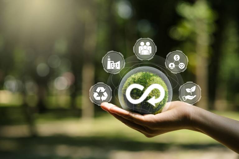 Hand of human holding green earth circular economy icon. Circulating in an endless cycle, Business and world sustainable environment concept.