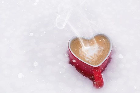 Heart shaped coffee cup on snow.