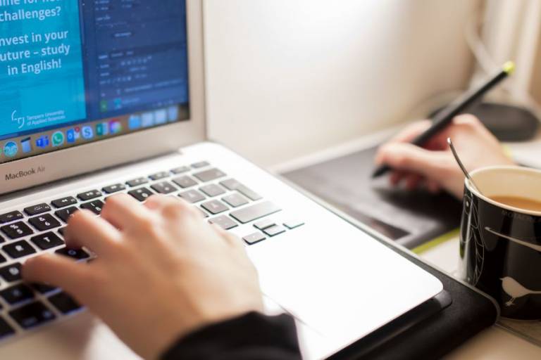 Käsi tietokoneen näppäimistöllä.