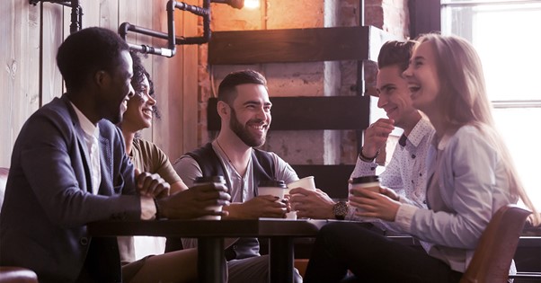 Five people sitting around a table and discussing.