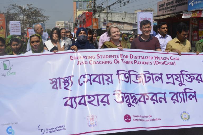 Ihmisiä seisomassa bannerin takana.