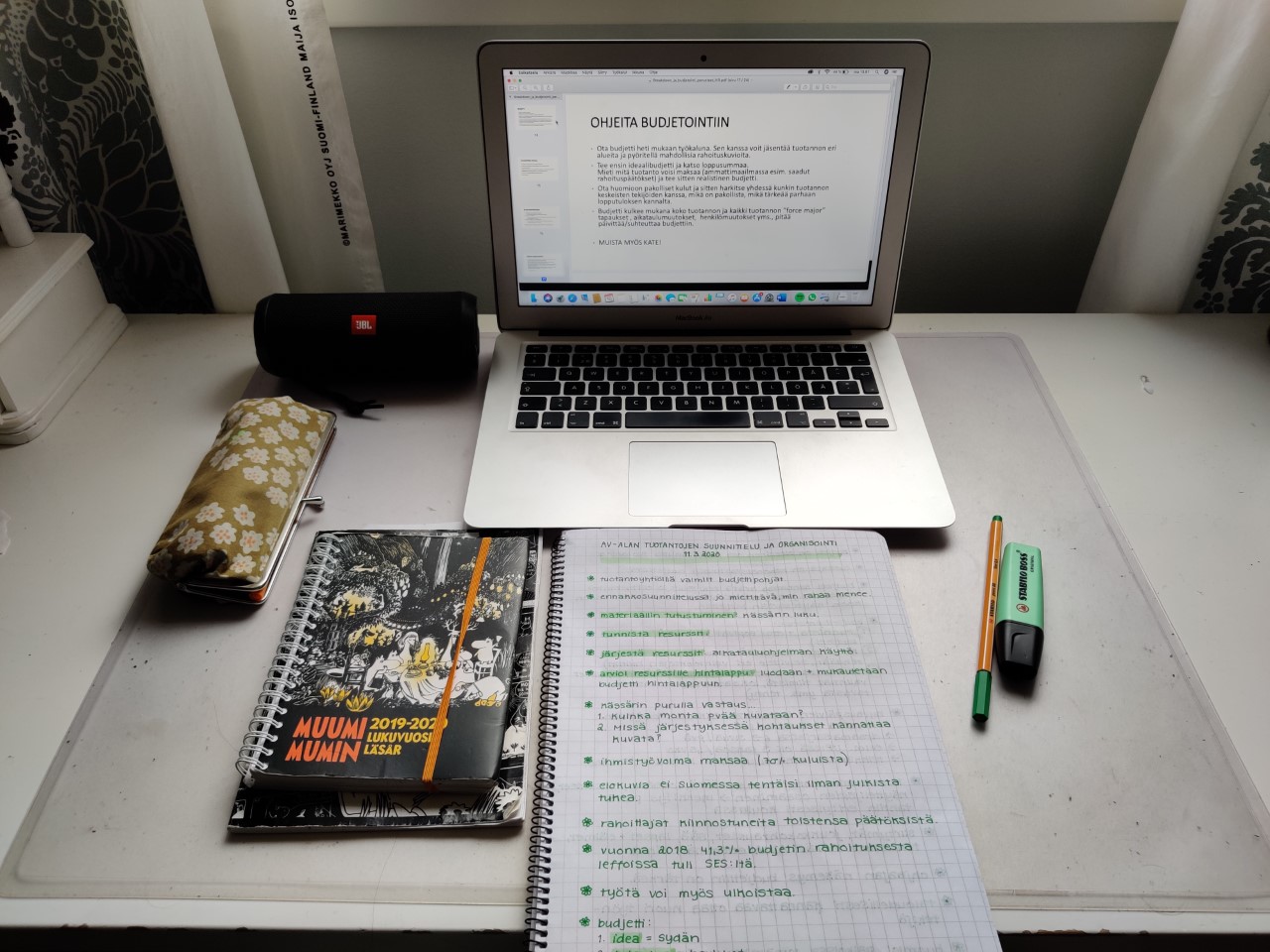 Medianomiopiskelijan työvälineet, pöydällä tietokone ja muistiinpanovälineet