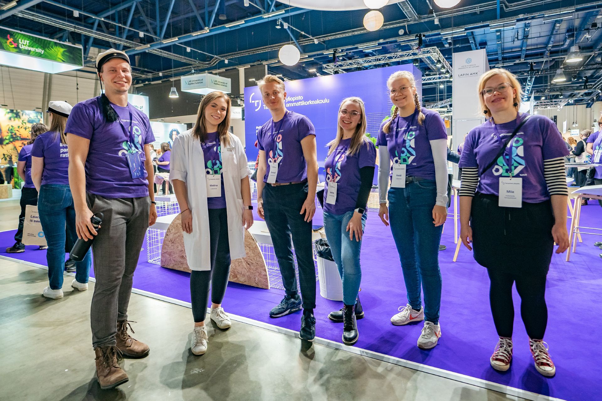 Kuusi opiskelijalähettilästä rivissä hymyilemässä kameralle.