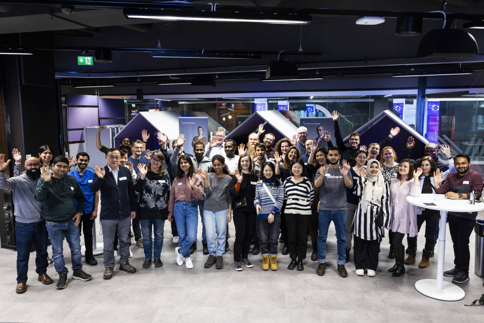 Group of people smiling and waving.