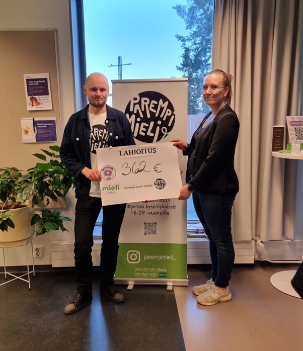 Kaksi ihmistä seisovat ja pitävät kylttiä, jossa lukee "lahjoitus".