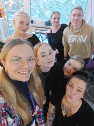 Kuvassa kuusi hyväntuulista tulevaa sairaanhoitaja-alumnia ja entinen tuutor-opettaja.