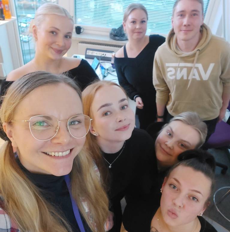 Kuvassa kuusi hyväntuulista tulevaa sairaanhoitaja-alumnia ja entinen tuutor-opettaja.