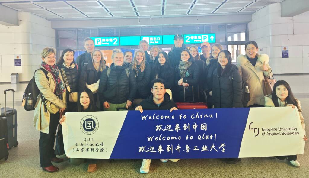 People standing in a group behind banner.