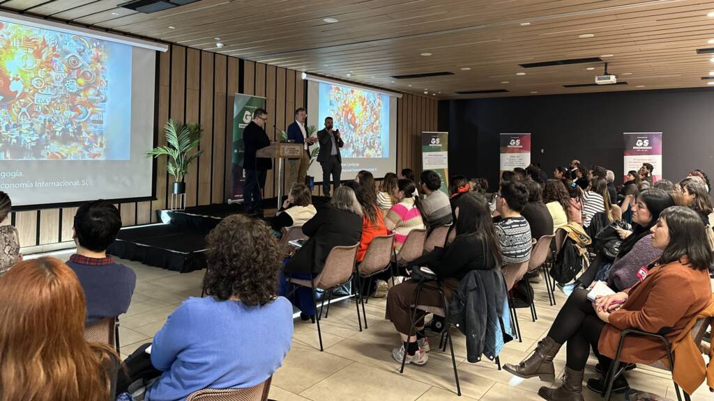 People sitting in chairs and looking towards the stage in a seminar.