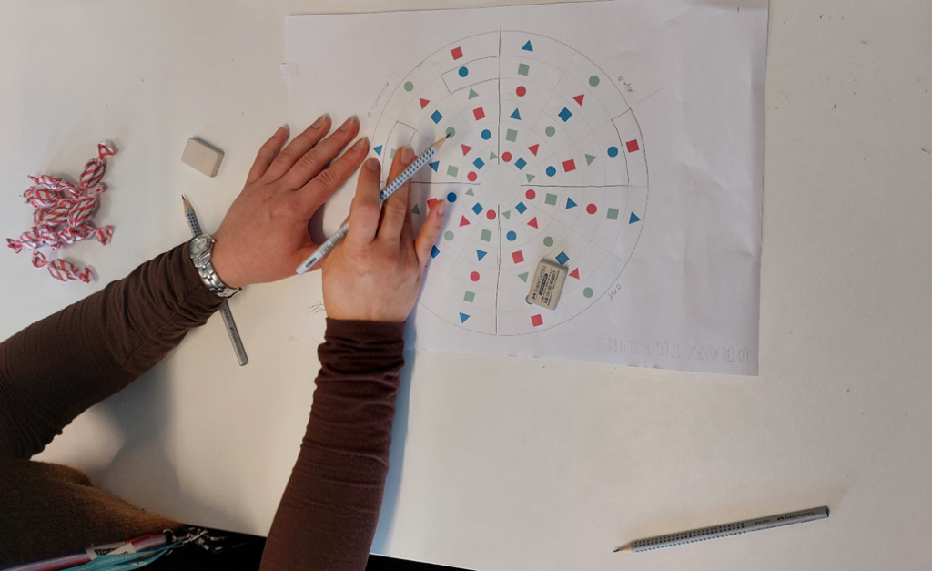 Hands drawing on the gameboard-like paper