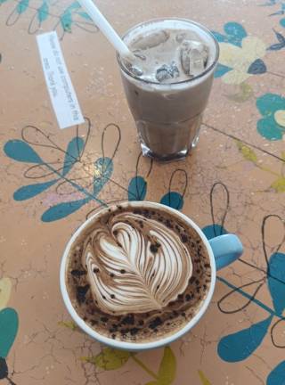 Kahvikuppi, jossa maidolla tehty lehtikuvio