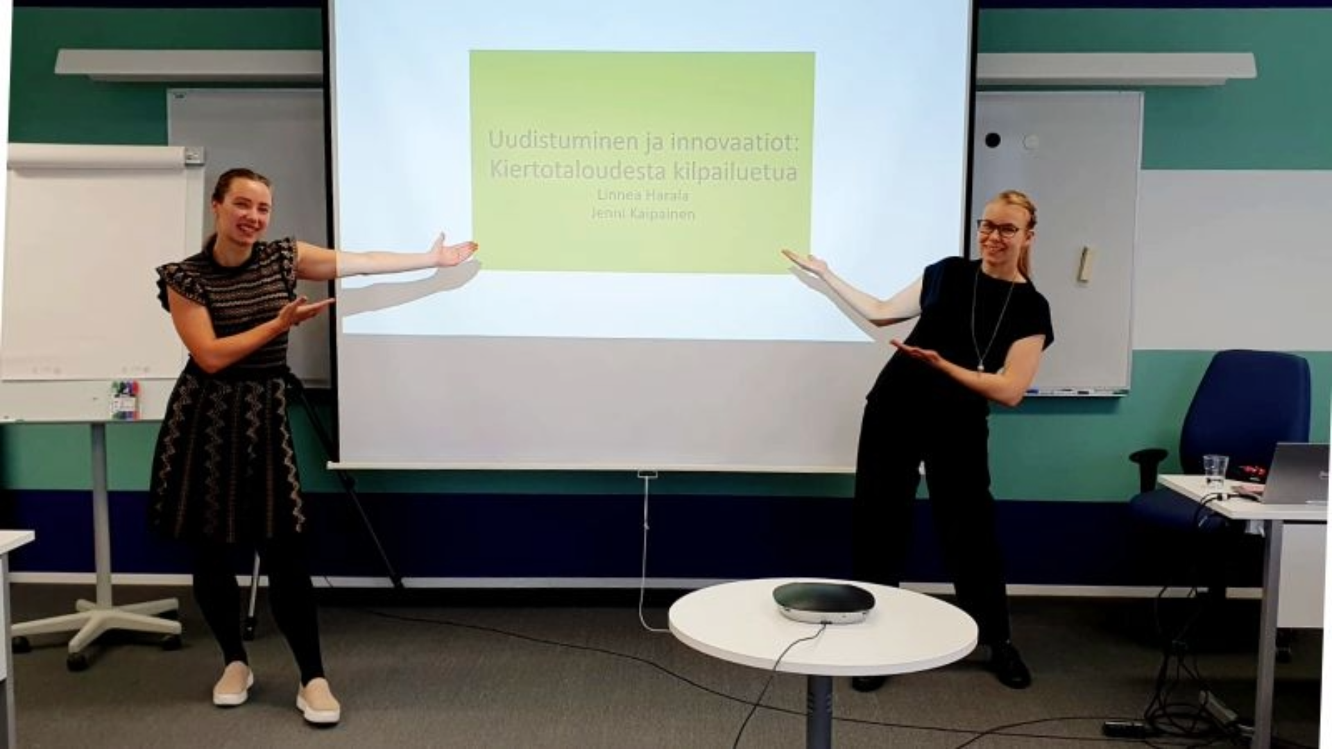 Kaksi väitökirjatutkijaa osoittaa esittelynäyttöä.