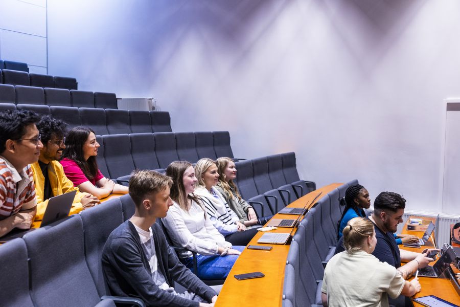 Opiskelijoita istuu luentosalissa.